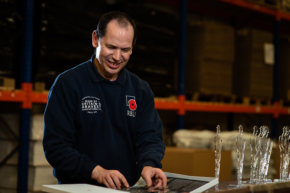 Man packing Tommy silhouettes in factory.